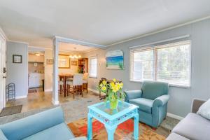 a living room with blue chairs and a table at 1 Mi to Sands Beach Walkable Island Home with Yard! in Port Royal