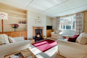 ein Wohnzimmer mit zwei Sofas und einem Kamin in der Unterkunft Coldburn Cottage in Kirknewton