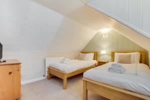 zwei Betten in einem Zimmer mit Dachboden in der Unterkunft Coldburn Cottage in Kirknewton