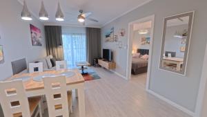 une salle à manger et un salon avec une table à manger et un salon dans l'établissement GARDENIA Apartament Przy Plaży 17, à Dziwnów