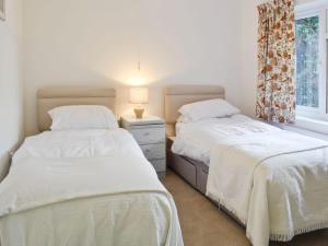 two beds sitting next to each other in a bedroom at Sisial y Llyn in Bala