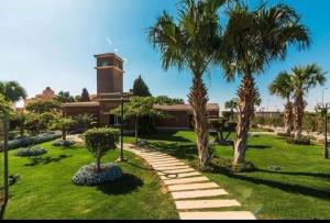 a park with palm trees and a building at الفيروز in 6th Of October
