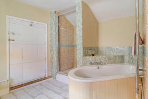 a large bathroom with a tub and a shower at Coach House Cottage in Wickham Market +28 photos