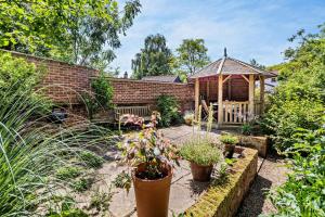 a garden with a gazebo and some plants at Coach House Cottage in Wickham Market