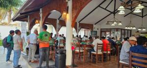 a group of people standing outside of a restaurant at La Choza Bungalows in Tambo Grande