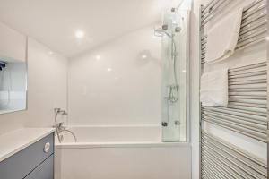 La salle de bains blanche est pourvue d'une douche et d'une baignoire. dans l'établissement Beeston Sea View, à Sheringham 18 autres photos