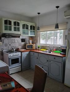 a kitchen with blue cabinets and a white stove top oven at Encasa in Gualeguaychú