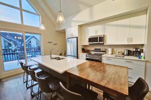 a kitchen with a large wooden table and chairs at Cloudline Vista 3 BdrmTownhouse with Garage managed by Little Sister Getaways in Canmore