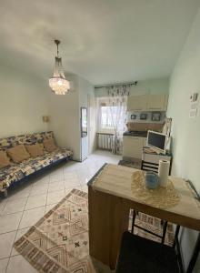 a living room with a couch and a table at Appartamento Lella Acqui terme zona corso bagni in Acqui Terme