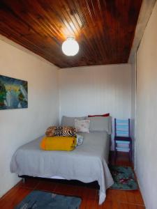 a bedroom with a bed and a blue chair at Suíte vista maravilhosa in Ouro Preto