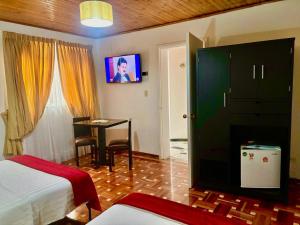 a hotel room with a bedroom with a table and a bed at Casa Coliving 121 in Bogotá