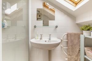 a white bathroom with a sink and a shower at Stone Cottages - Bodham in Bodham +19 photos