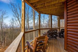 a porch of a cabin with chairs and tables at Climbing to New Heights cabin in Cartertown