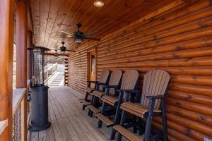 a row of chairs on a porch with a heater at Climbing to New Heights cabin in Cartertown