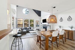 une salle à manger et un salon avec une table et des chaises dans l'établissement Les Eaux Luxe Mountain View Condo Private Sauna, à Mont-Tremblant