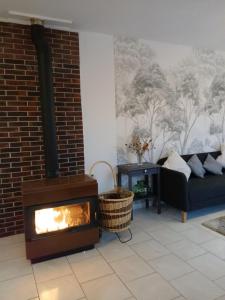 a living room with a fireplace and a couch at La maison du verger in Magny-Fouchard