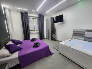 1 dormitorio con cama morada y bañera en Holiday Home Suite, en Giardini Naxos
