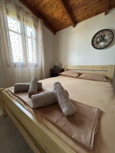a bedroom with two beds and a clock on the wall at Ziras Traditional Villa in Áno Váthia
