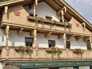 a building with potted plants on a balcony at Der Waidachhof Zillertal in Hainzenberg