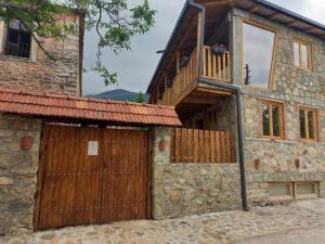 an old stone house with a wooden door and a balcony at Villa Old House BN in Bitola