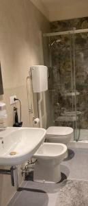 Un baño con lavabo, inodoro y ducha. en buonconsiglio 199, en Trento