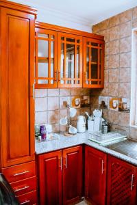 Una cocina con gabinetes de madera y encimera. en Rhovee Homes, en Uru