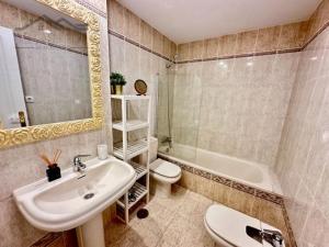 a bathroom with a sink and a toilet and a tub at Faro Bay in Estepona +3 photos