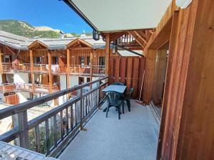 a balcony of a cabin with a table and chairs at Résidence Les Airelles - appartement en duplex - Garage couvert - 50 m des pistes de ski MAE-4114 in Montgenèvre +9 photos