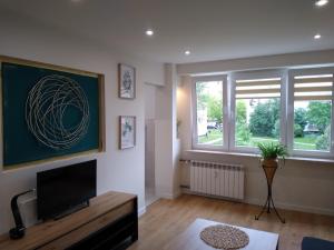 a living room with a tv and a window at Apartament Bocianek in Kielce