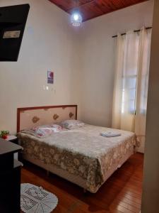 a bedroom with a bed and a window at Pousada Sayonara in Atibaia