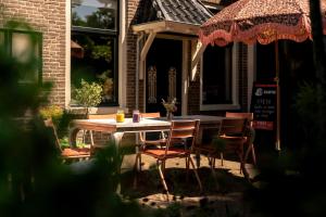 a wooden table and chairs on a patio at Pieks Noordlaren in Noordlaren