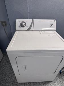 a white washing machine sitting next to a wall at Beach Retreat Oceanview Townhome with Pool & Game Room - Steps to Beach in Clearwater Beach