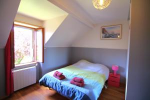 a bedroom with a bed with two pink stuffed animals on it at Longère des Alix in Pornichet +13 photos