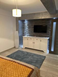 a living room with a tv on a brick wall at Central Luxury Apartament in Tulcea
