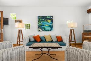 a living room with a blue couch and two lamps at BlueMoon Villa - Authentic, seaside living in Trou dʼ Eau Douce