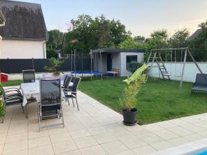 a backyard with a table and chairs and a playground at Villa au calme avec piscine et jacuzzi in Riedwihr