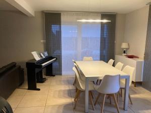 a dining room with a table and a piano at Villa au calme avec piscine et jacuzzi in Riedwihr