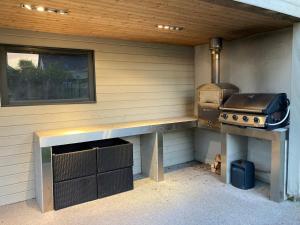 an outdoor kitchen with a grill and a stove at Villa au calme avec piscine et jacuzzi in Riedwihr