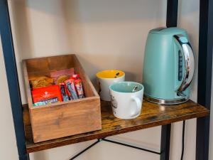 a wooden shelf with a coffee maker and cups on it at Hole House Farm in Millom