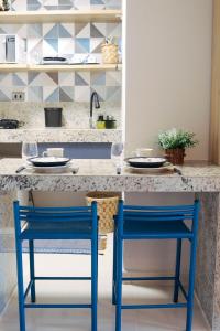 a kitchen with two blue chairs at a kitchen counter at Luxo Frente Mar | Nobile #220 in Tambaú