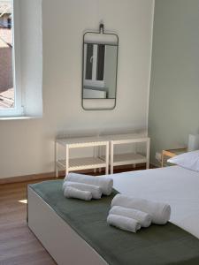 a bedroom with two towels on a bed with a mirror at La Filanda Apartment in Castelvetro di Modena