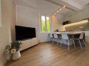 a living room with a kitchen and a table with chairs at La Filanda Apartment in Castelvetro di Modena