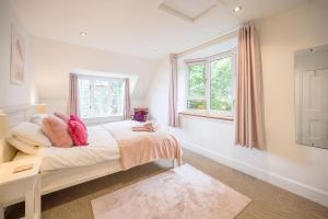 a bedroom with a bed and two windows at Tower Cottage, Walberswick in Walberswick