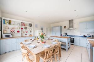 a kitchen with a wooden table and chairs in a kitchen at Tower Cottage, Walberswick in Walberswick