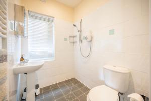 a white bathroom with a toilet and a sink at Tower Cottage, Walberswick in Walberswick +32 photos