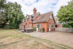 a large brick house with a yard in front of it at Tower Cottage, Walberswick in Walberswick