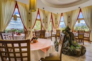 a dining room with tables and chairs and windows at Hotel REDYK Ski&Relax in Ząb