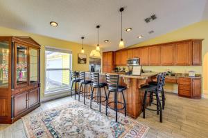 ジャクソンビルにあるCanal-Front Retreat 4 Mi to Jacksonville Beach!のキッチン(木製キャビネット、バースツール付)