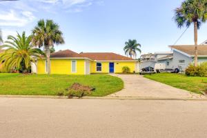 ジャクソンビルにあるCanal-Front Retreat 4 Mi to Jacksonville Beach!のヤシの木と私道のある黄色い家