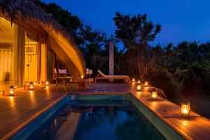 a house with a pool and a deck with lights at Uga Chena Huts - Yala - All Inclusive in Yala